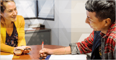 Two people are talking and taking notes